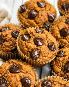 close-up of pumpkin muffins with chocolate chips in paper liners on a cooling rack
