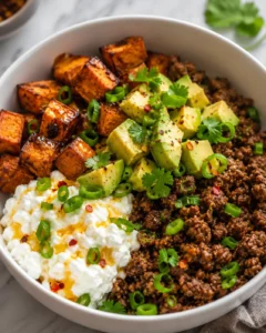 Colorful ground beef protein bowl with sweet potatoes, avocado, and cottage cheese