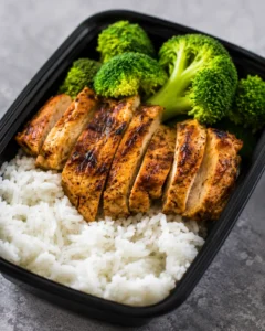 Prepared chicken, rice, and broccoli in a meal prep container.