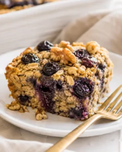 Delicious slice of make-ahead high protein baked oatmeal with blueberries and walnuts.