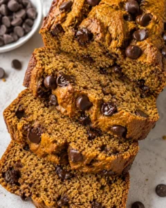 Close-up of sliced chocolate chip banana bread with a chewy golden crust and melty chips