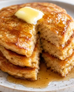 Close-up of fluffy cottage cheese pancakes topped with butter and syrup