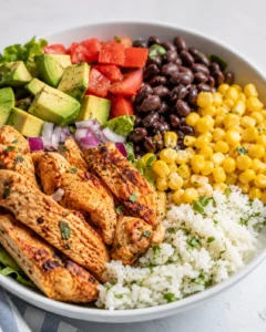 Chicken Burrito Bowl with grilled chicken, cilantro-lime rice, black beans, corn, avocado and tomatoes in a bowl