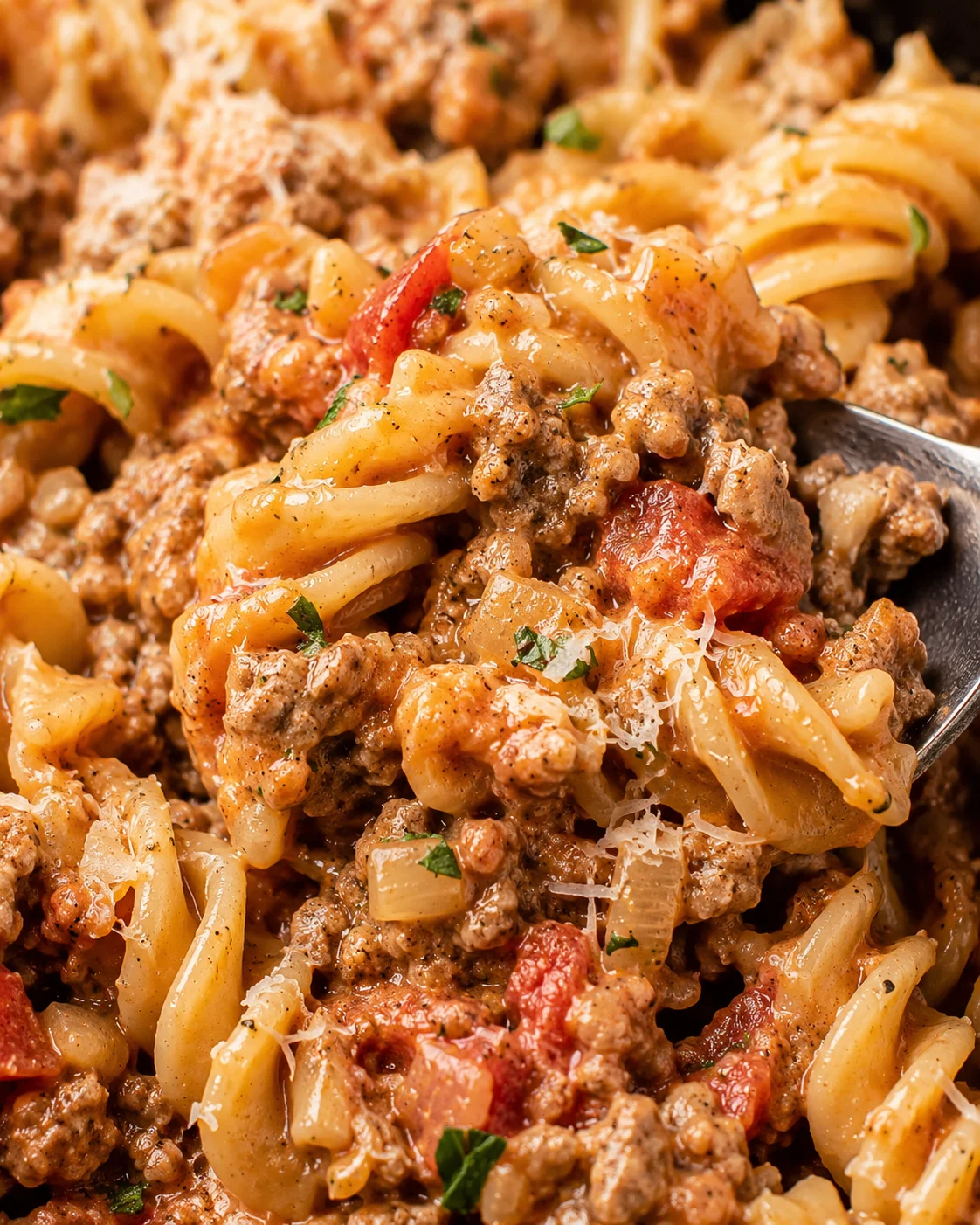 Spoonful close-up of creamy ground beef pasta showing sauce and pasta texture