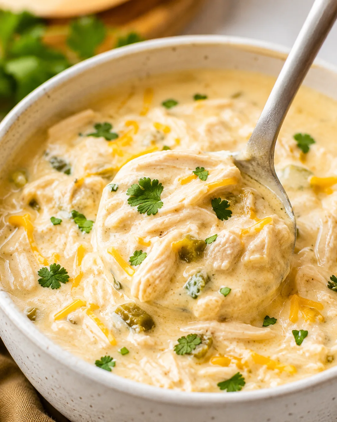 Bowl of creamy keto white chicken chili with shredded chicken, green chiles and cilantro