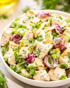 Bowl of Greek yogurt chicken salad with grapes, celery, dill, and sliced almonds