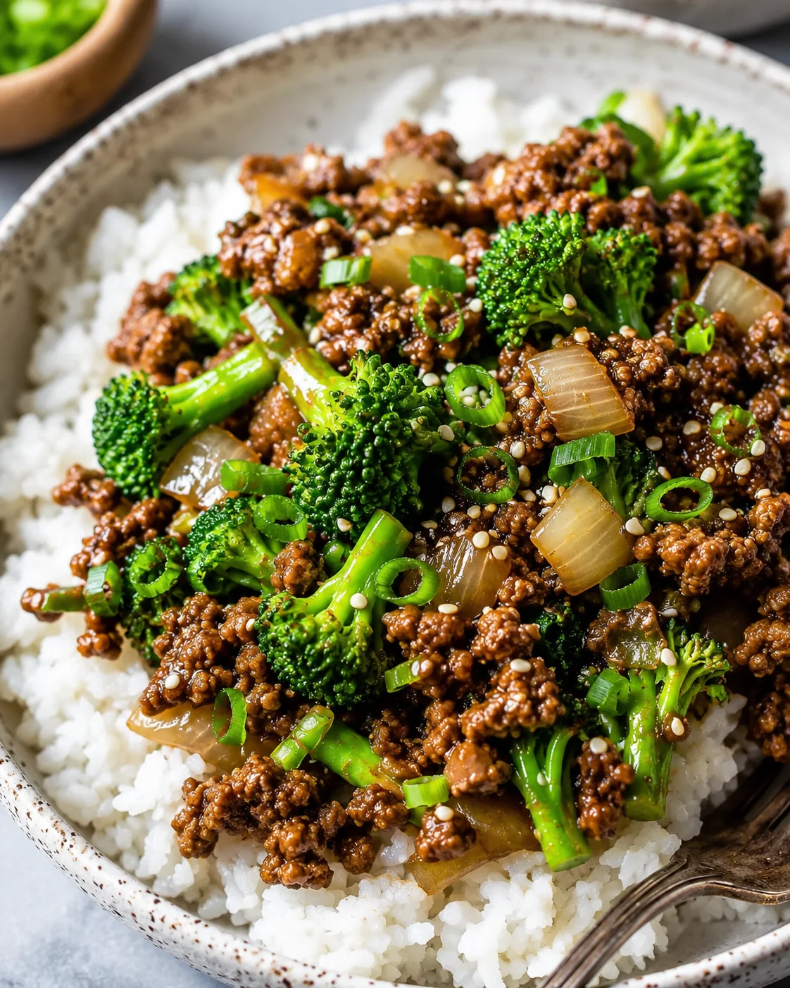 Bowl of ground beef and broccoli stir fry served over rice