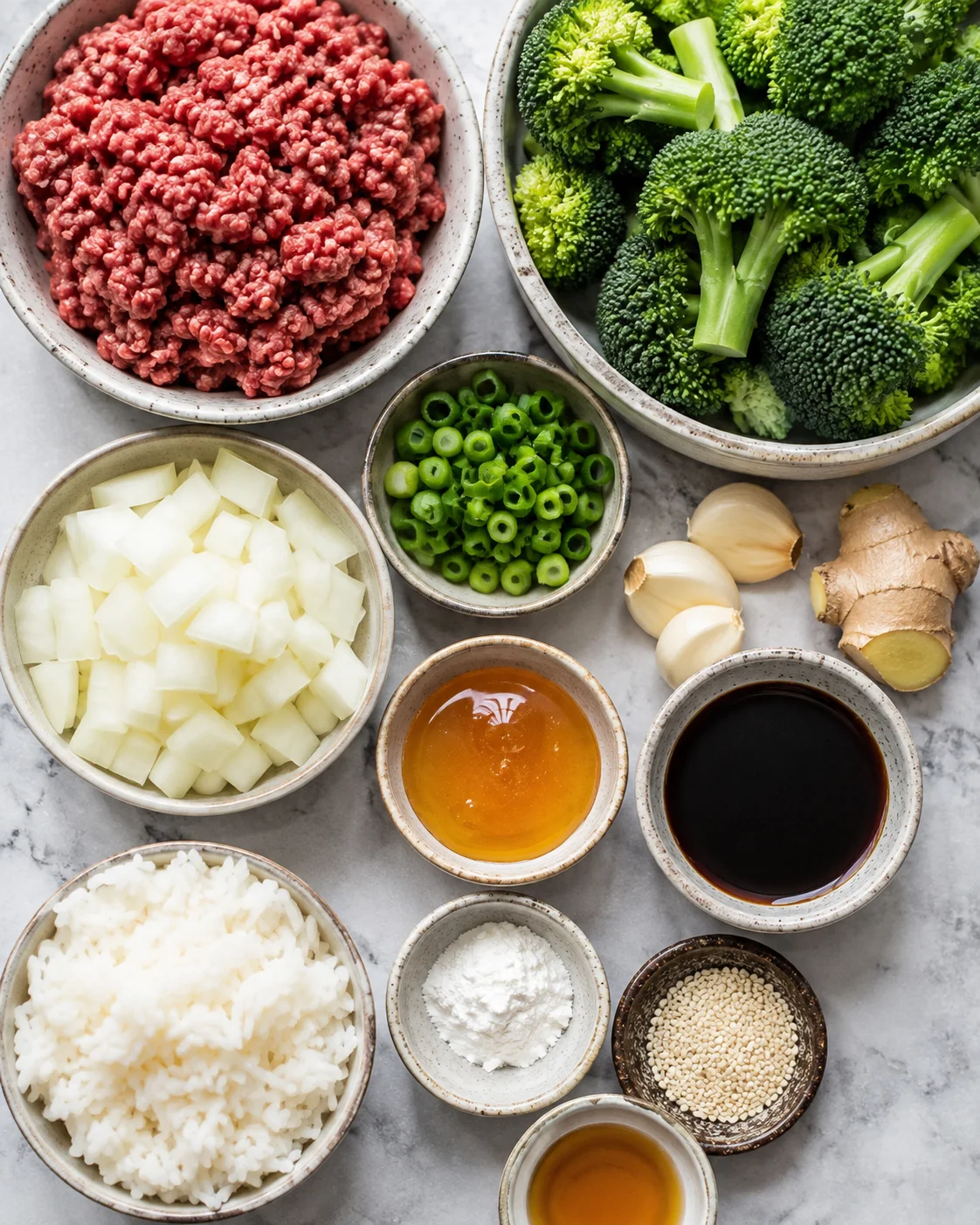 Top-down view of ingredients for ground beef and broccoli stir fry arranged in bowls