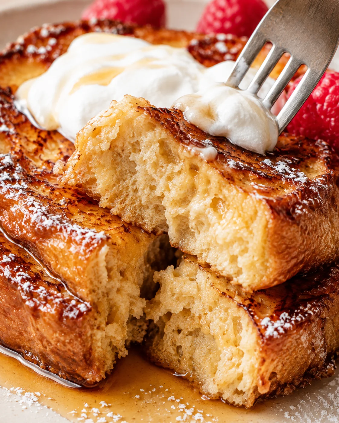 Fork pulling into the soft interior of high protein French toast showing crumb and syrup