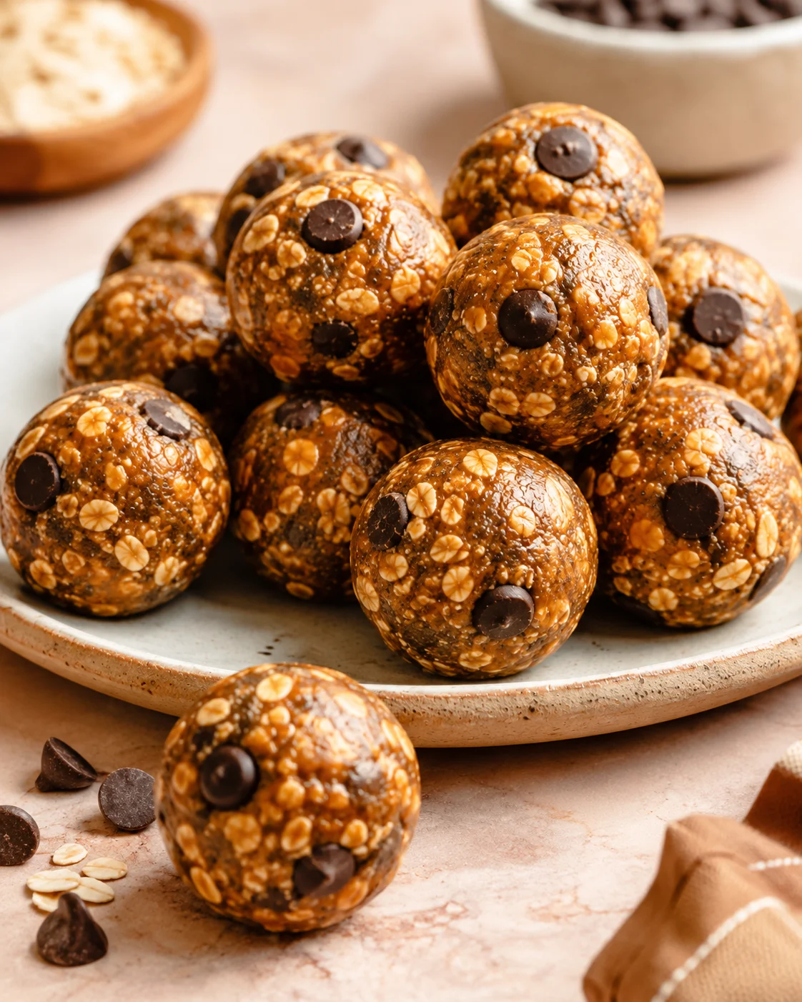 No Bake Pumpkin Spice Energy Bites stacked on a plate with one bite in the foreground