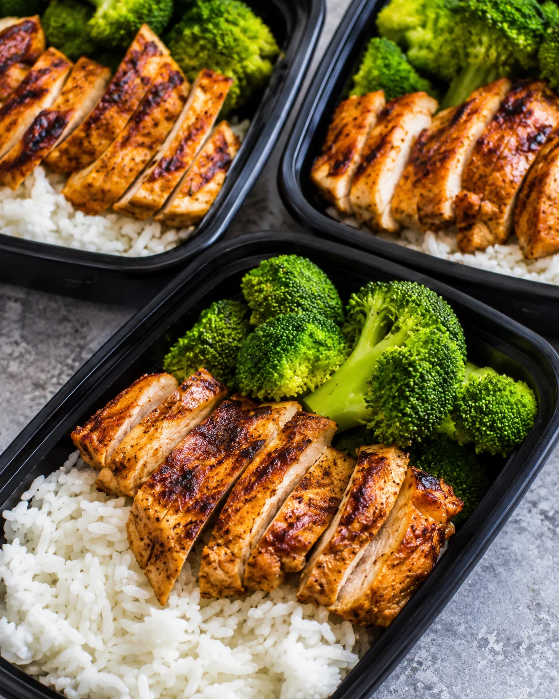Prepared meal prep containers with grilled chicken, rice, and steamed broccoli.