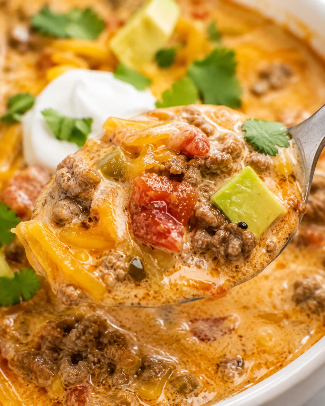 Close-up of creamy, cheesy keto taco soup with toppings and cilantro
