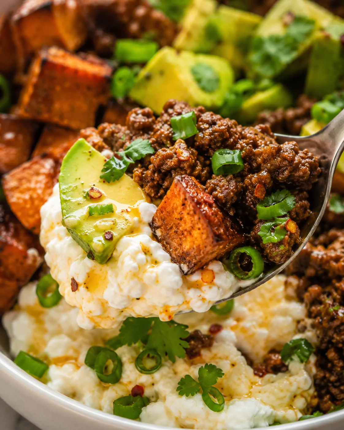 Colorful ground beef protein bowl with sweet potatoes, avocado, and cottage cheese