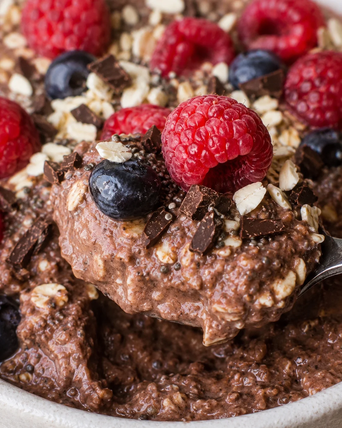 Colorful vegan breakfast bowls with berries, chocolate, and toppings