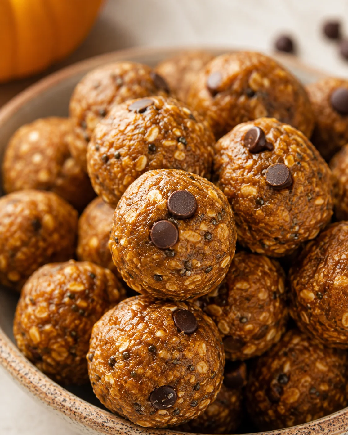 Close-up of chewy, spiced pumpkin protein balls with chocolate chips in a bowl