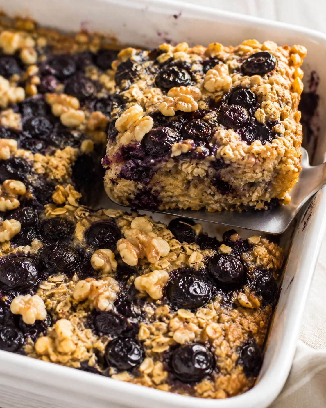 Close-up of baked oatmeal with blueberries and walnuts in a baking dish