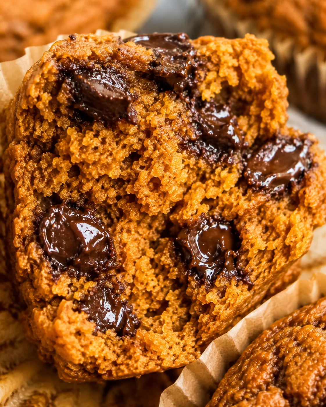 Close-up of a cut muffin with gooey chocolate chips and crumbly topping