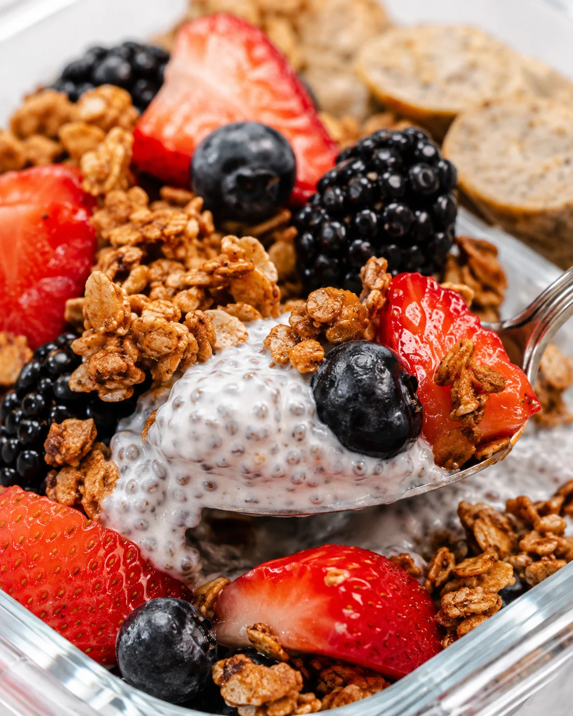 Close-up of a yogurt parfait with granola and mixed berries in a glass dish