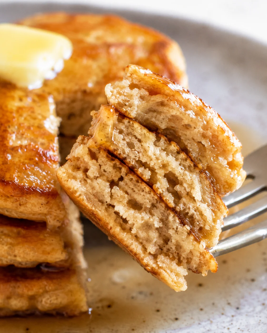 Close-up of fluffy cottage cheese pancakes with a fork and butter
