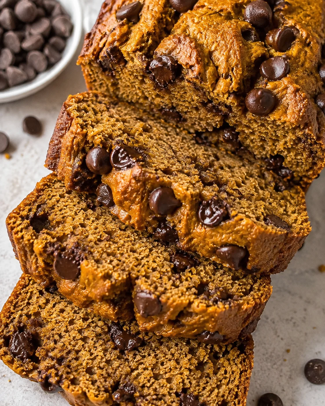Close-up of sliced chocolate chip banana bread with a chewy golden crust and melty chips