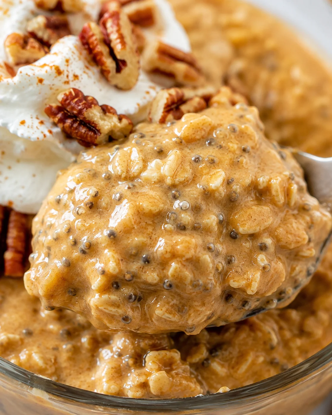 Close-up of a spoonful showing the creamy oats and chia seeds in pumpkin overnight oats