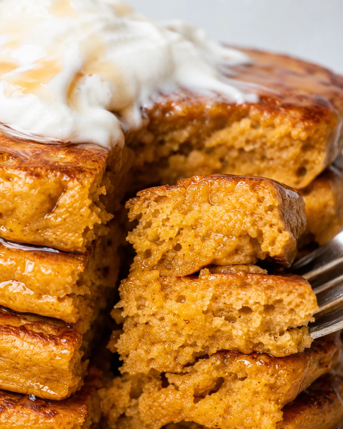 Close-up of the interior crumb of pumpkin protein pancakes with syrup and yogurt visible