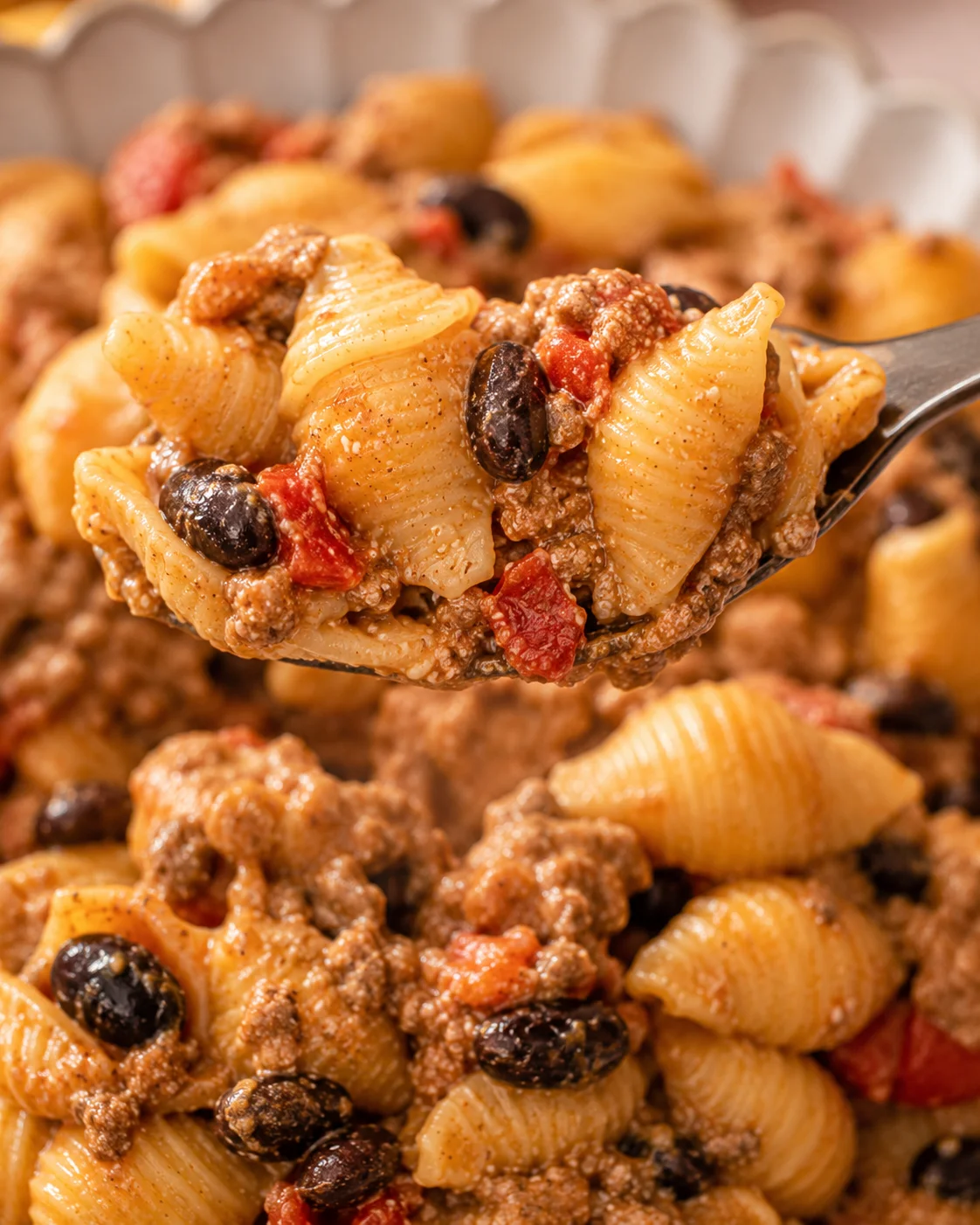 Forkful of easy healthy taco pasta showing shells, black beans and seasoned beef