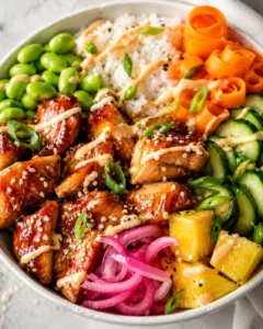 Teriyaki chicken poke bowl with glazed chicken, rice, edamame, pineapple, pickled red onions and cucumber