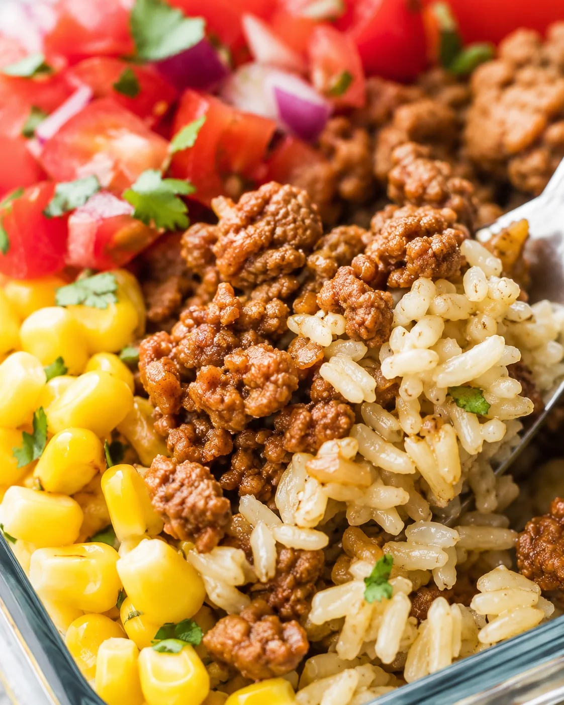 Close-up detail of seasoned turkey, brown rice and corn in a turkey taco meal prep bowl